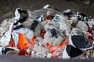 BBQ Grill Pit Glowing And Flaming Hot Charcoal Briquettes coal Food Background Or Texture Close-Up Top View
