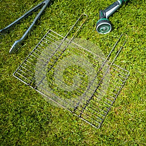 BBQ grillage rost lying on the wet lawn