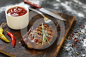 Bbq, Grilled beefsteaks, rosemary, wooden cutting board, dinner preparation, closeup. copy space, selective focus,