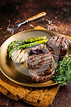BBQ grilled Fillet Mignon Steak with asparagus, beef tenderloin meat. Dark background. Top view