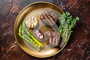 BBQ grilled Fillet Mignon Steak with asparagus, beef tenderloin meat. Dark background. Top view