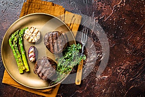 BBQ grilled Fillet Mignon Steak with asparagus, beef tenderloin meat. Dark background. Top view. Copy space