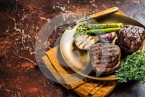 BBQ grilled Fillet Mignon Steak with asparagus, beef tenderloin meat. Dark background. Top view. Copy space