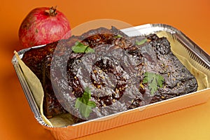 BBQ grilled ribs in a metal tray for delivery. Take out concept, eating at home. In foil delivery box, food take away