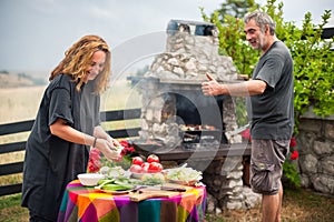 BBQ grilling party. Couple in garden making barbecue grill