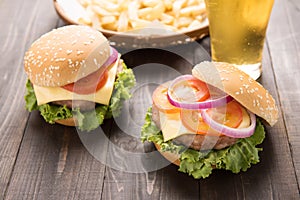 bbq hamburger with french fries and beer on the wooden background.