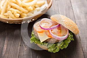 Bbq hamburger with french fries on the wooden background.