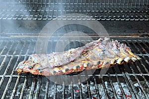 BBQ hot flaming grill is roasting marinated pork a ribs