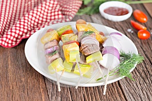 Bbq meat on sticks, kebab skewers with sauce, on wooden background. Traditional barbecue grill food.