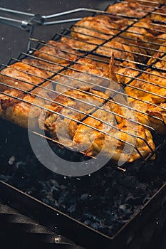 BBQ picnic time Roasted chicken legs and wings on grill. Grilling meat on outdoor grill grid tasty barbeque chicken