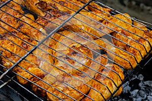 BBQ picnic time Roasted chicken legs and wings on grill. Grilling meat on outdoor grill grid tasty barbeque chicken