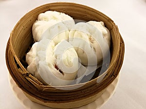 BBQ pork steam bun on the bamboo basket, bamboo tray in the local tradional chinese food in China town with blur background table