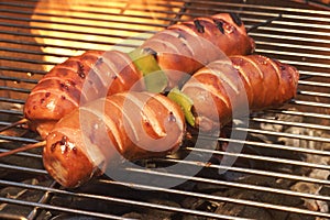 BBQ Spit Roasted Fatty Sausage On The Hot Flaming Grill