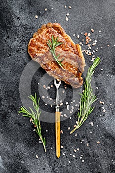 BBQ Strip New York steak or striploin. Black background. Top view
