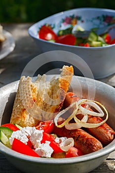 BBQ. Village lunch. grilled sausages with vegetable salad, onion and grilled bread.