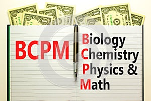 BCPM biology chemistry physics math symbol. Concept words BCPM biology chemistry physics math on white note on beautiful dollar