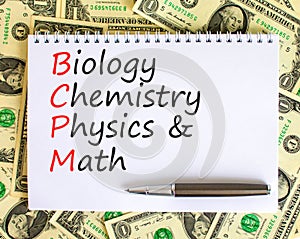 BCPM biology chemistry physics math symbol. Concept words BCPM biology chemistry physics math on white note on beautiful dollar