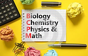 BCPM biology chemistry physics math symbol. Concept words BCPM biology chemistry physics math on white note on beautiful yellow