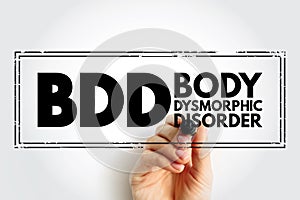 BDD - Body Dysmorphic Disorder is a mental health disorder, acronym text concept stamp photo