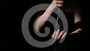 BDSM concept. A woman in a leather dress holds a black whip with a long fringe. Role-playing games for adults. Close-up