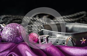 Bdsm still life leather collar shibari rope and christmas ball on pink cloth close up