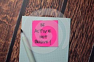 Be Active Not Passive! write on sticky notes isolated on office desk