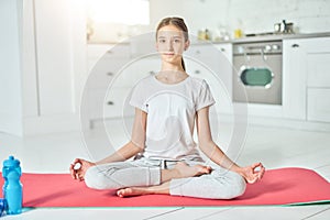 Be in balance. Attractive hispanic teenage girl in sportswear looking at camera while practicing yoga, meditating on a