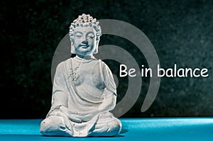 Be in balance - inspiration phrase with little white meditate buddha. Zen, yoga and life concept