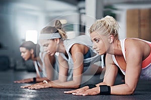 Be the best you can be. three women doing pushups at the gym.