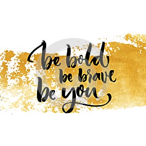 Be bold, be brave, be you. Inspiration saying calligraphy on golden dry brush stroke.