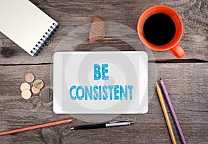 Be Consistent. Tablet device on a wooden table photo