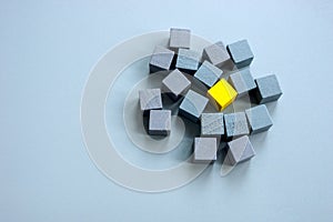 Be different and unique concept. Yellow cube surrounded by gray ones.
