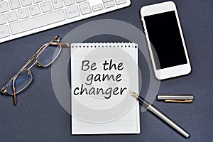 Be the game changer. Text on notebook