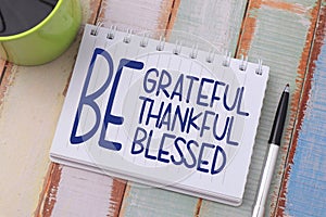 Be grateful thankful blessed, text words typography written on book against wooden background, life and business motivational photo