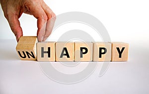 Be happy, do not unhappy symbol. Businessman turns the wooden cube and changes the word `unhappy` to `happy`. Beautiful white