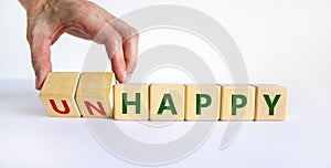 Be happy, do not unhappy symbol. Businessman turns wooden cubes and changes the word `unhappy` to `happy`. Beautiful white