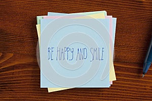 Be happy and smile handwritten on note