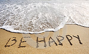 Be happy words written on beach sand-positive thinking concept