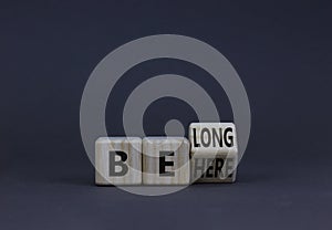 Be here belong symbol. Turned a wooden cube and changed concept words Be here to Belong. Beautiful grey background. Business,