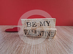 Be my Valentine, the inscription on the brick blocks on the background of a red heart. Beautiful red and wooden background
