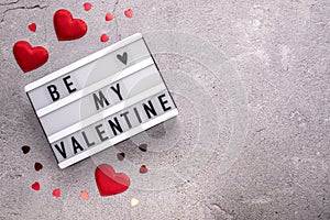 Be my Valentine light box with red hearts on cement background with copy space