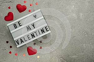 Be my Valentine light box with red hearts on cement background with copy space