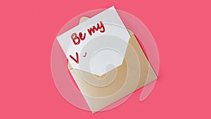 Be my Valentine. Text on a piece of paper in an envelope. Love letter, declaration of love for valentine`s day