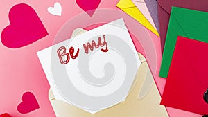 Be my Valentine. Text on a piece of paper in an envelope. Love letter, declaration of love for valentine`s day