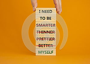 Be myself symbol. Businessman hand. Wooden blocks with words `i need to be myself, not smarter, thinner, prettier, better`.