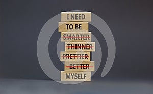 Be myself symbol. Businessman hand. Wooden blocks with words `i need to be myself, not smarter, thinner, prettier, better`.