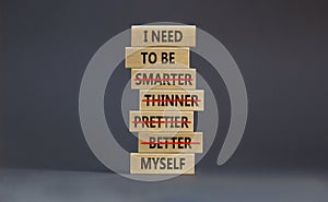 Be myself symbol. Businessman hand. Wooden blocks with words `i need to be myself, not smarter, thinner, prettier, better`. photo