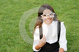 Be nice. childhood happiness. back to school. funny kid in park. relax on green grass with glasses. cheerful child ready