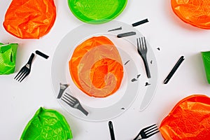 Be plastic free. Single-use colorful broken plastic plates and forks on a white background. Stop plastic pollution