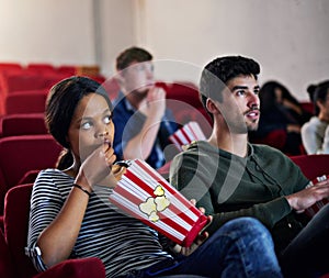 Be riveted by great movies. people watching a suspenseful movie in a cinema.